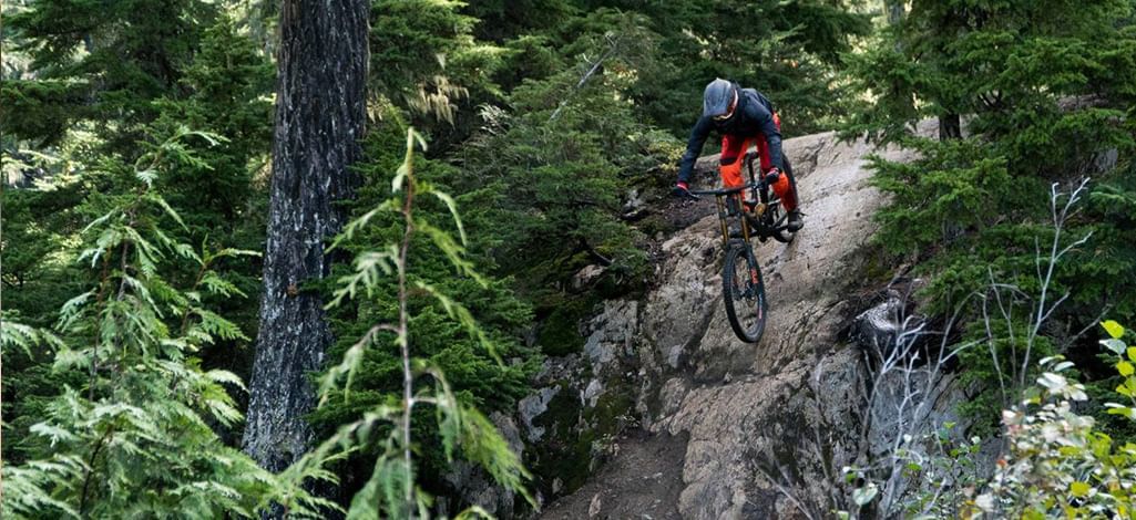 Rider tackling a rugged forest trail in Whistler Bike Park.