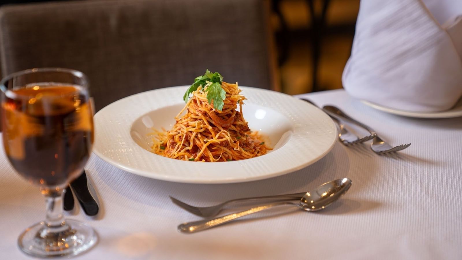 Swirl of spaghetti pasta with red sauce on a white plate in Al Firdous Restaurant at Saja Warwick Madinah 