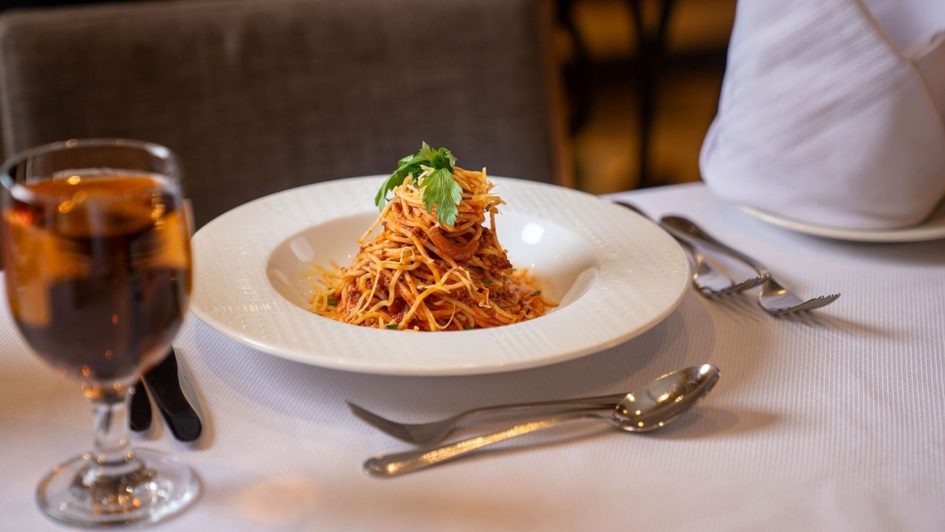 Swirl of spaghetti pasta with red sauce on a white plate in Al Firdous Restaurant at Saja Warwick Madinah 