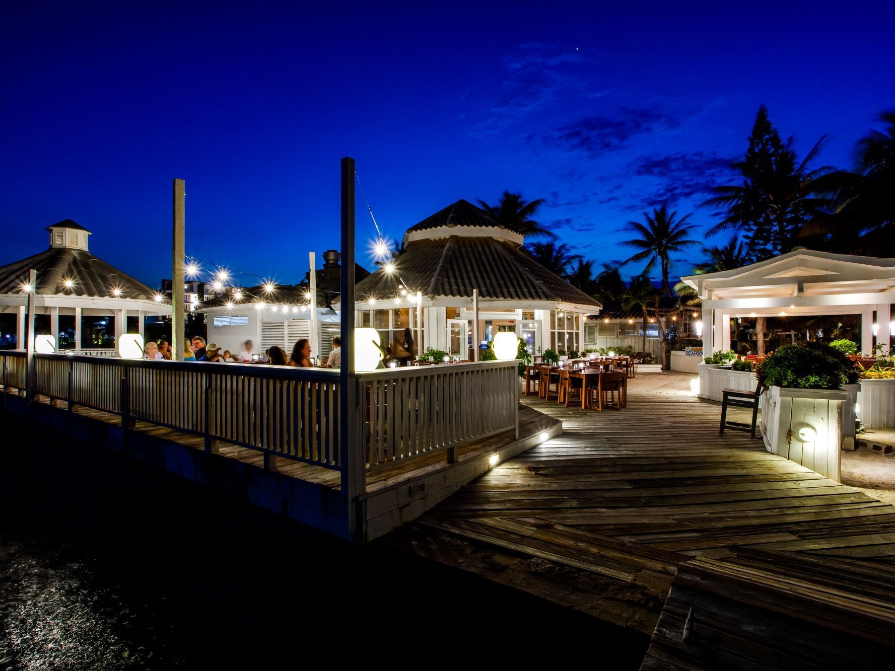 Exterior view of The Deck restaurant at night, Alaia Belize Autograph Collection