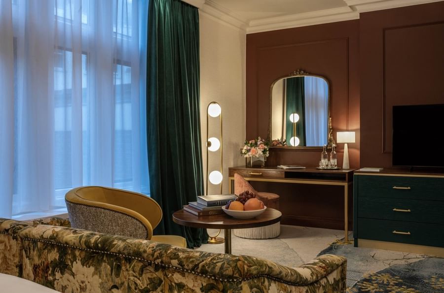 TV lounge with plush sofa with vanity table near window in Deluxe King at The Capital Hotel, Apartments and Townhouse