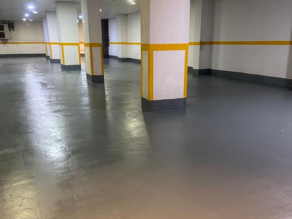 موقف سيارات تحت الأرض خالٍ في فنادق ومنتجعات وارويك، يضم أعمدة خرسانية مزينة بخطوط صفراء