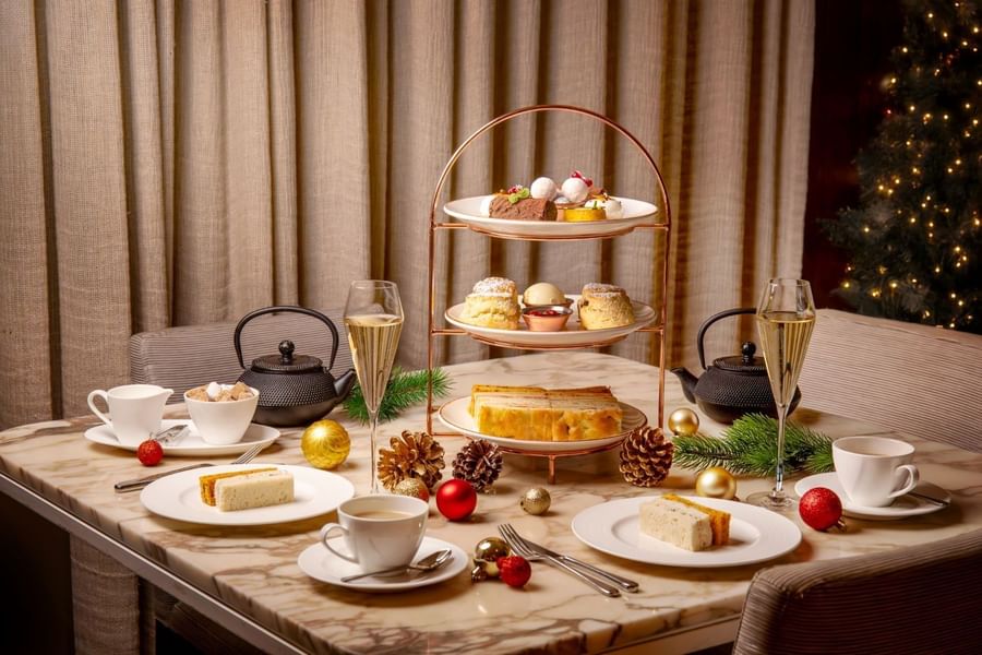 Festive afternoon tea setup with a tiered stand of treats and champagne at The May Fair Hotel