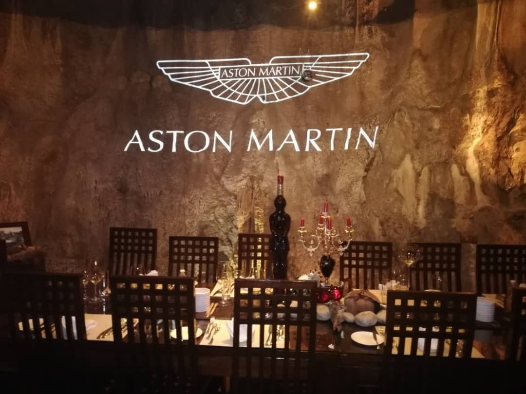 Dining table arranged by an Aston Martin sign at The Banjaran Hotsprings Retreat