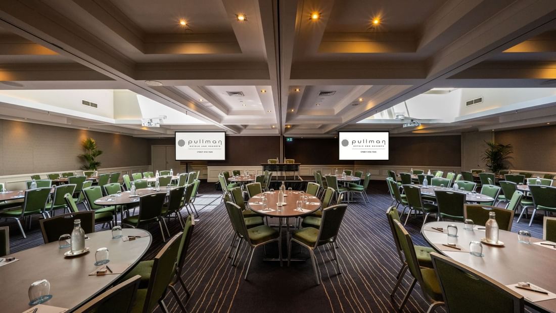 Banquet set-up with projector screens in Ibis Room at Pullman Sydney Hyde Park