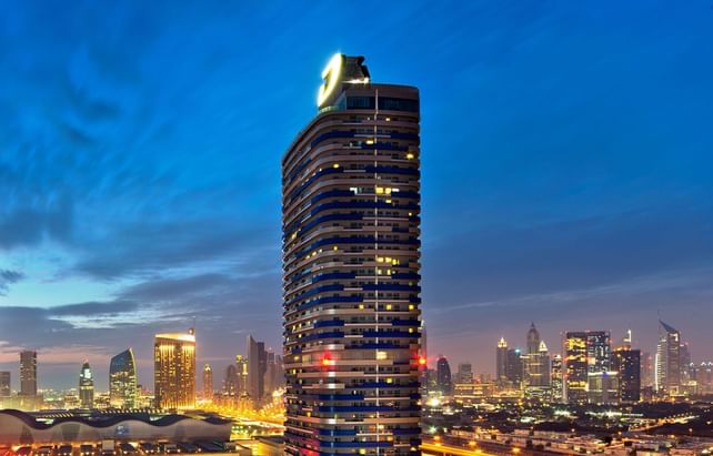 Aerial evening view of DAMAC Maison Mall street with city one of the 5 stars hotel in Dubai