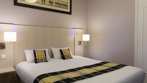King bed in a double bedroom at Hotel la Dousseine
