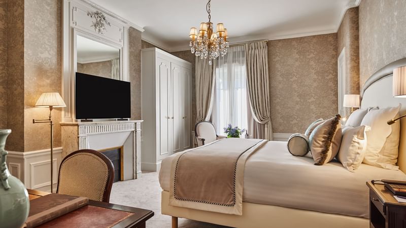 Executive Room with a bed, a chandelier, and a television above a classic fireplace at Hôtel Westminster - Paris