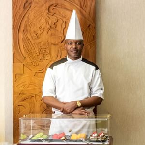 Chef posing with food showcase in front at Kampala Serena Hotel