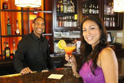 Man and woman enjoying a cocktail in Comfort Zone Bar & Grill at Rosen Inn Lake Buena Vista