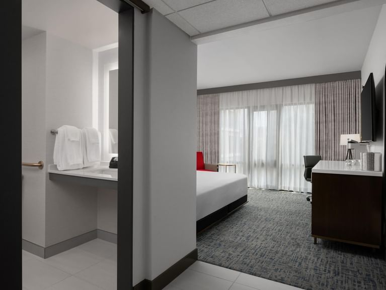 Boutique King from the doorway, showcasing the spacious and well-lit bathroom and a comfortable bedroom at Hotel 43 Boise