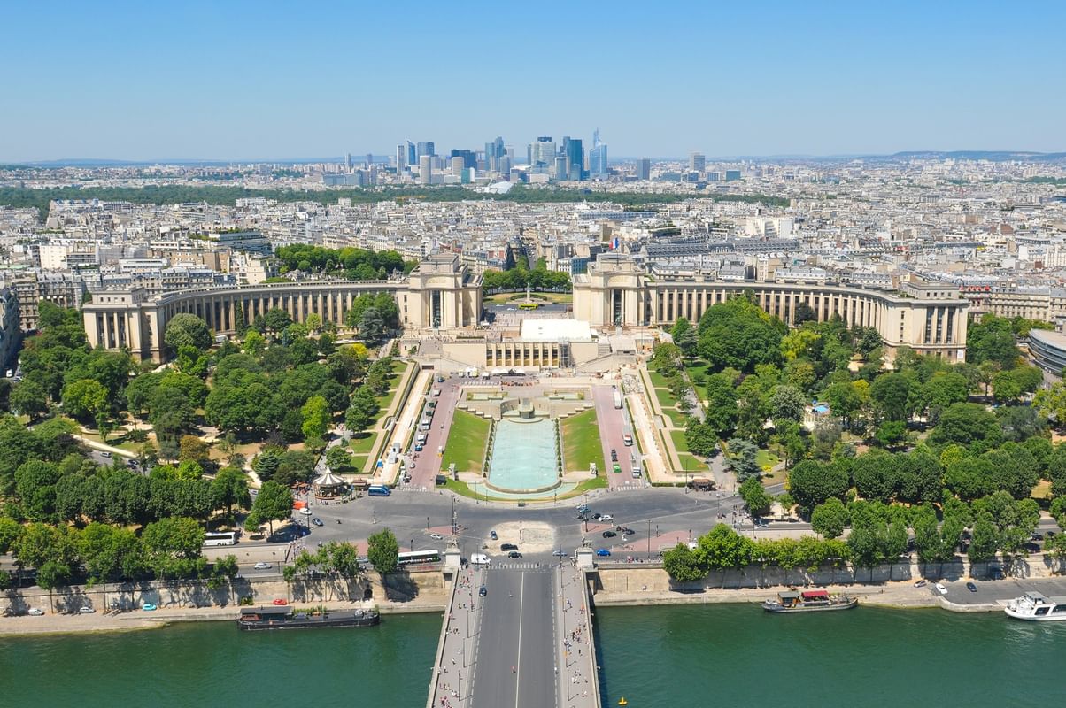 Trocadéro by a blue fountain under a clear sky, surrounding green park near Warwick Paris Champs Elysées