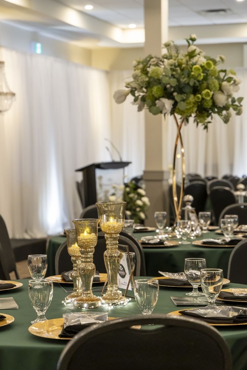 Gold candle holders on a round table by a floral piece at Rodd Miramichi River, a top choice for Miramichi events