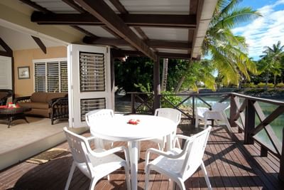 Lagoon Bures Patio with white table and chairs overlooking a tropical landscape at Musket Cove Island Resort & Marina