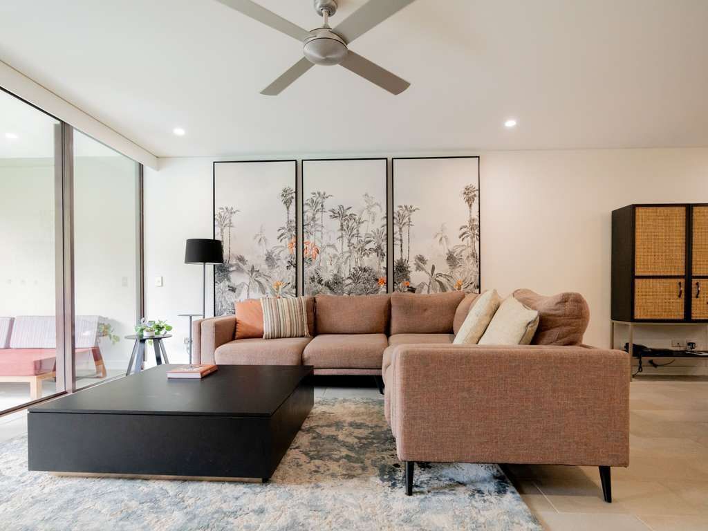 Cozy living area with comfortable couches and modern artwork in a hotel room at Pullman Palm Cove Sea Temple Resort & Spa