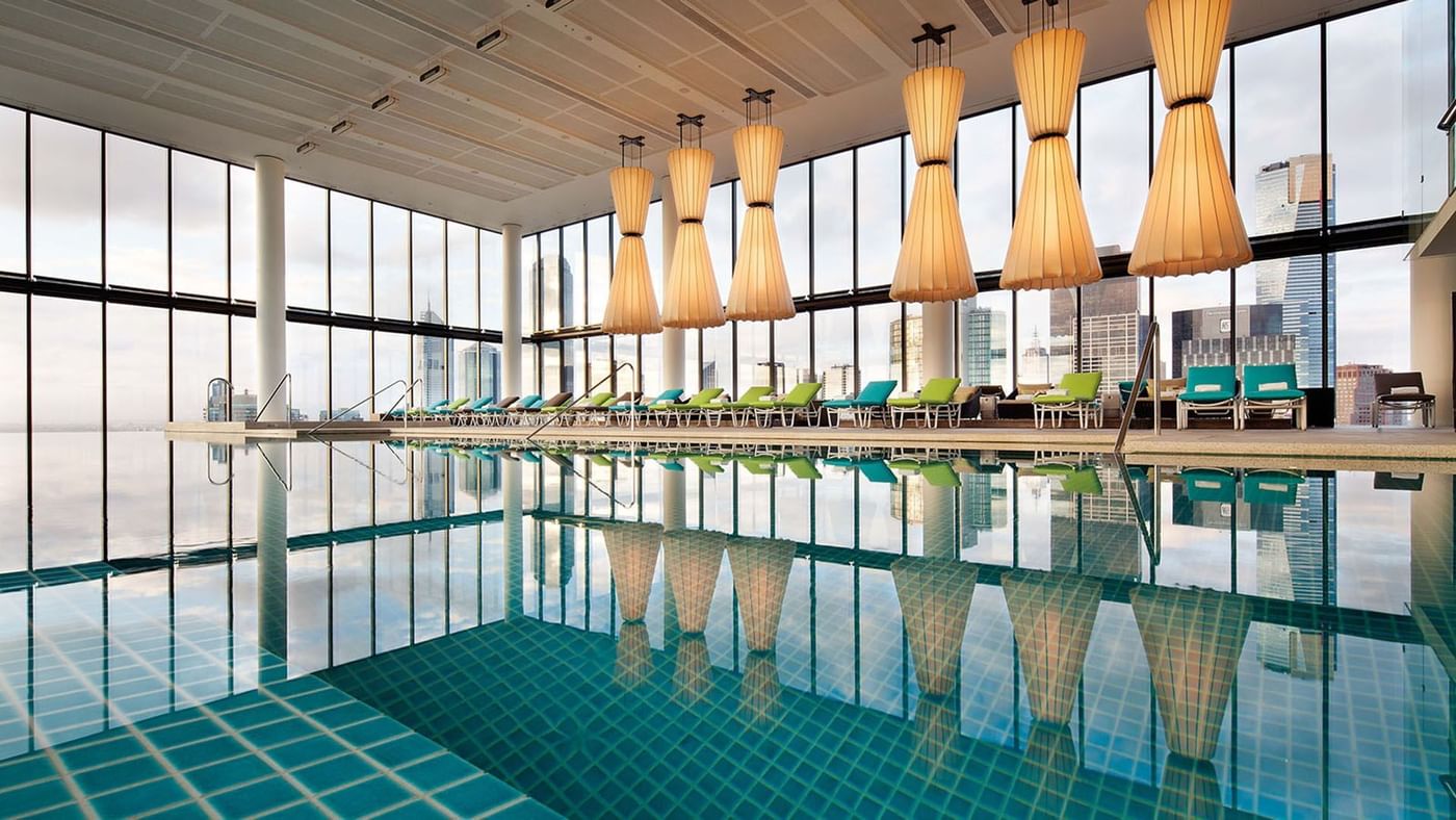 View of the indoor pool area with sunbeds & an outdoor view at Crown Metropol Melbourne