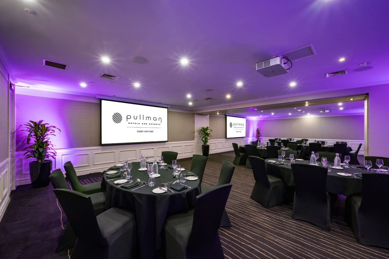 Banquet set-up with projector screens in Cook Room at Pullman Sydney Hyde Park
