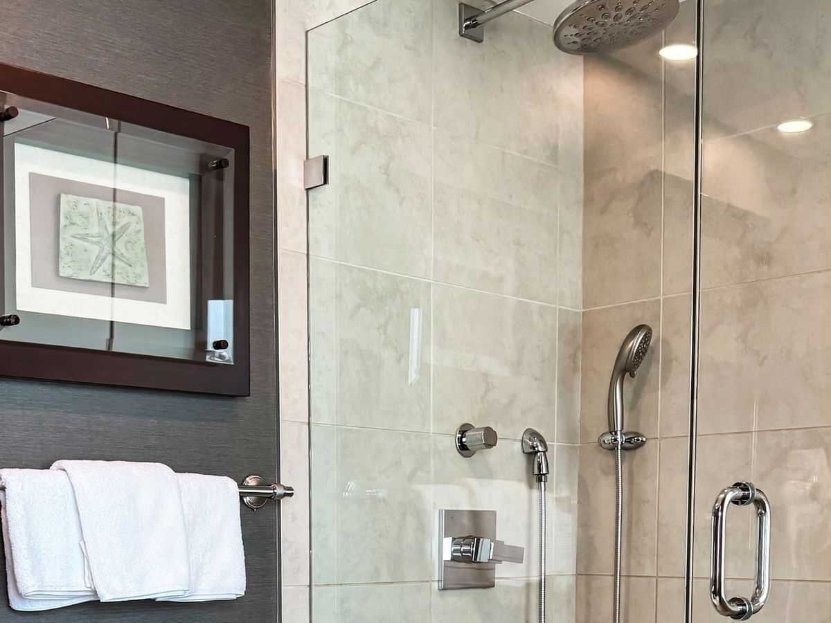 Coast Carrie Cates Penthouse Suite bathroom with glass shower, framed wall art at Coast Lonsdale Quay Hotel