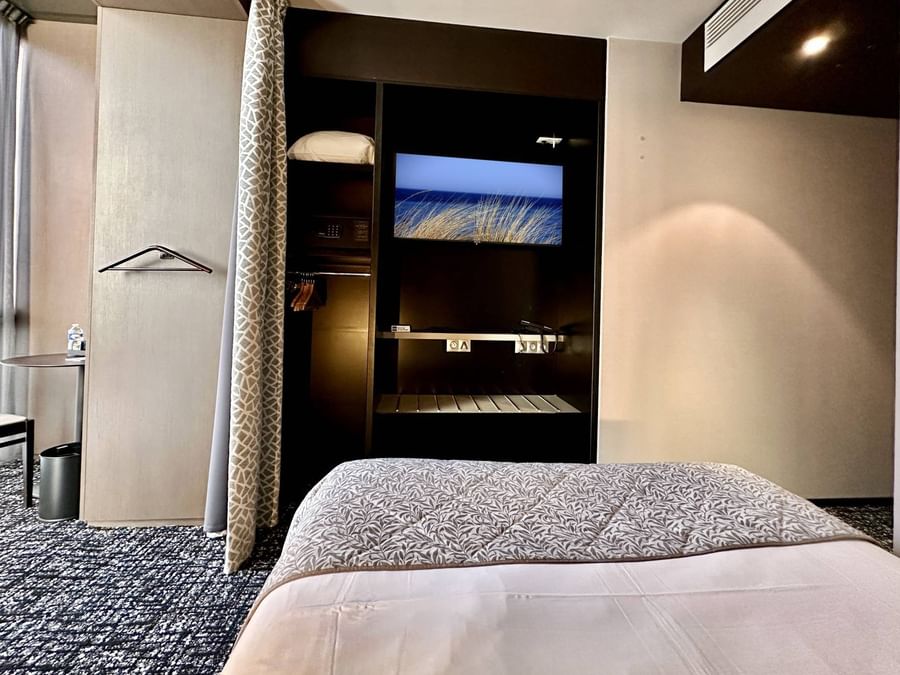 Chambre simple moderne avec télévision intégrée au mur à l'Hôtel de la Paix à Brest.