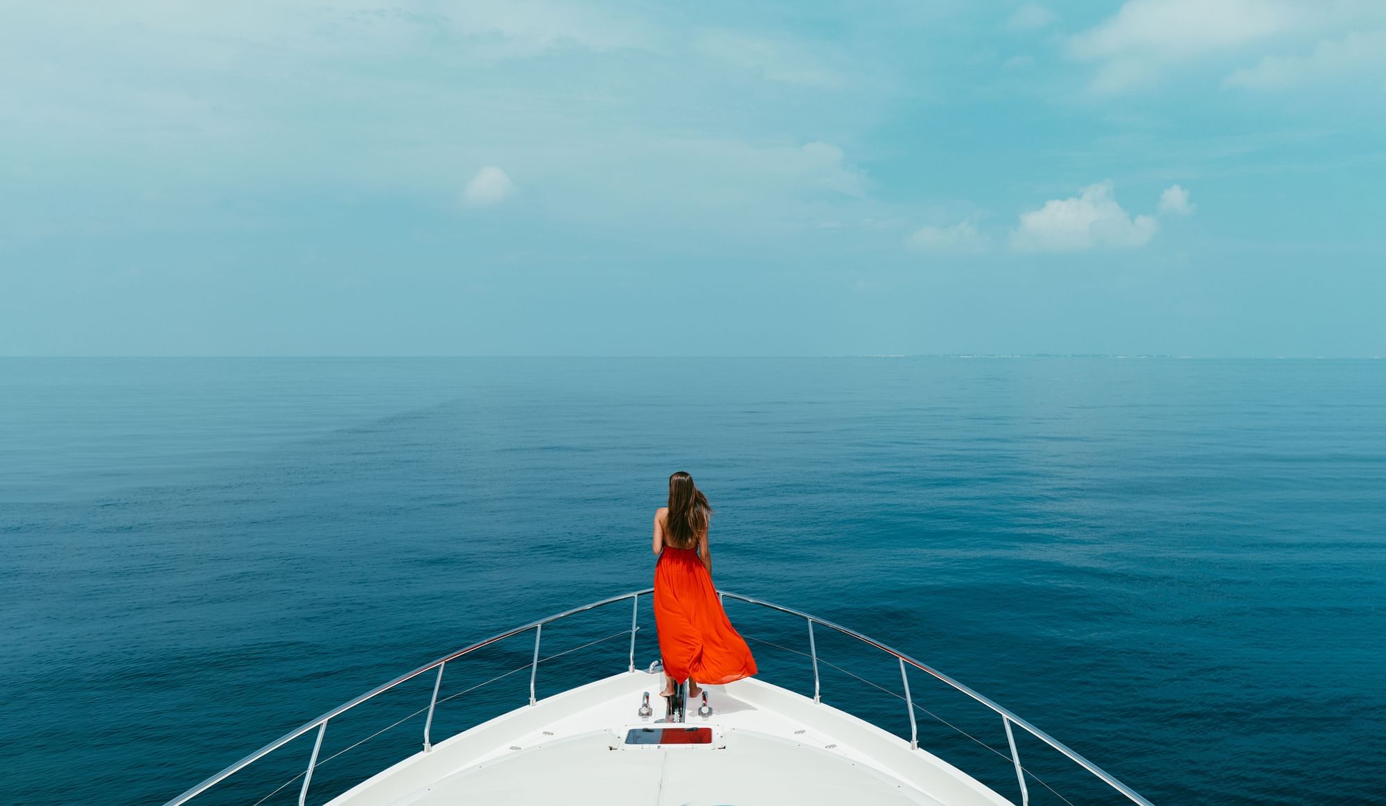 A lady on a yacht against the sea near The Signature Collection