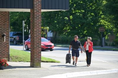Couple pulling a suitcase on the sidewalk near Rodd Grand Yarmouth, a prime choice for hotels in Yarmouth