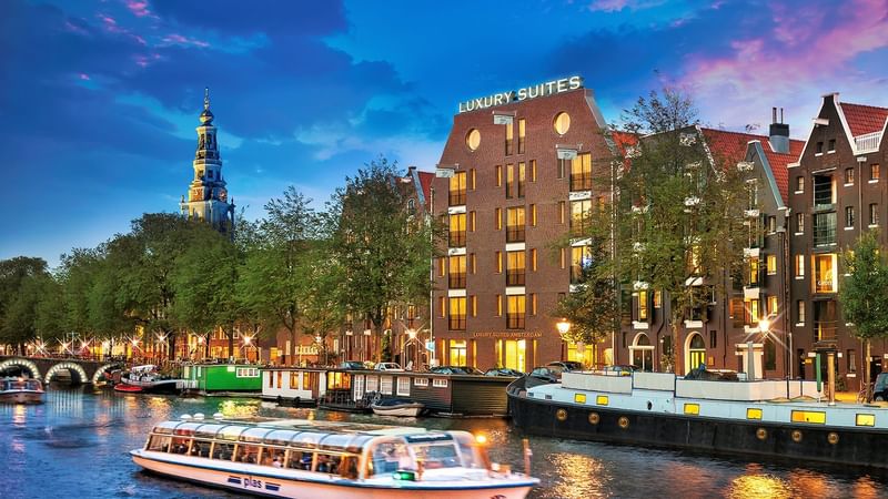 Evening city view with building lights near a lake poster used at Roc e Fiori