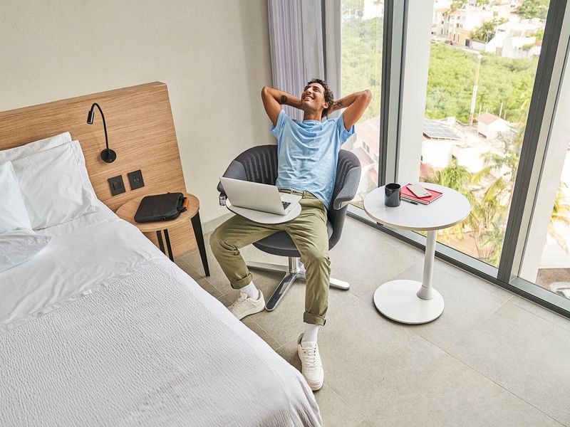 Man relaxing on a chair in a Suite at IOH Freestyle Hotels