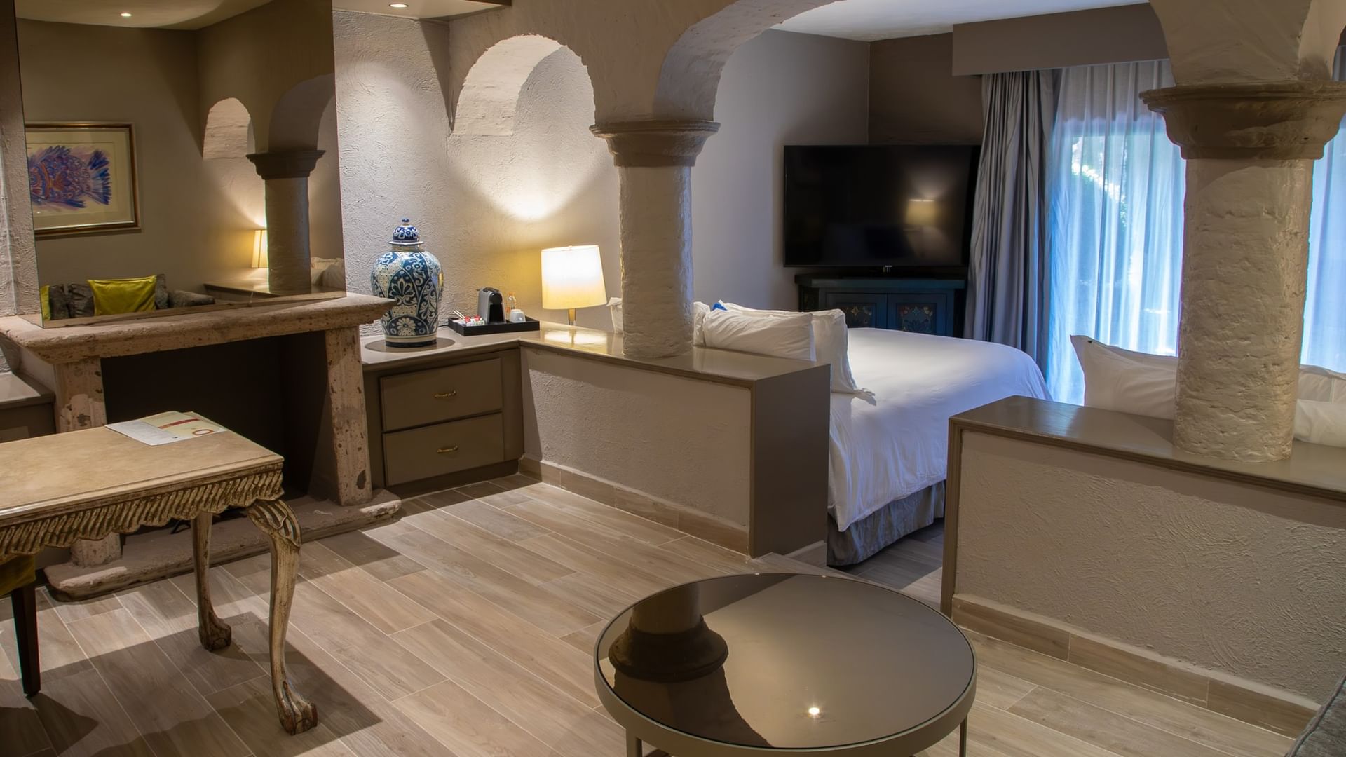 Suite espaciosa con arcos coloniales, dos camas dobles, televisión y ventanas amplias en Quinta Real Guadalajara
