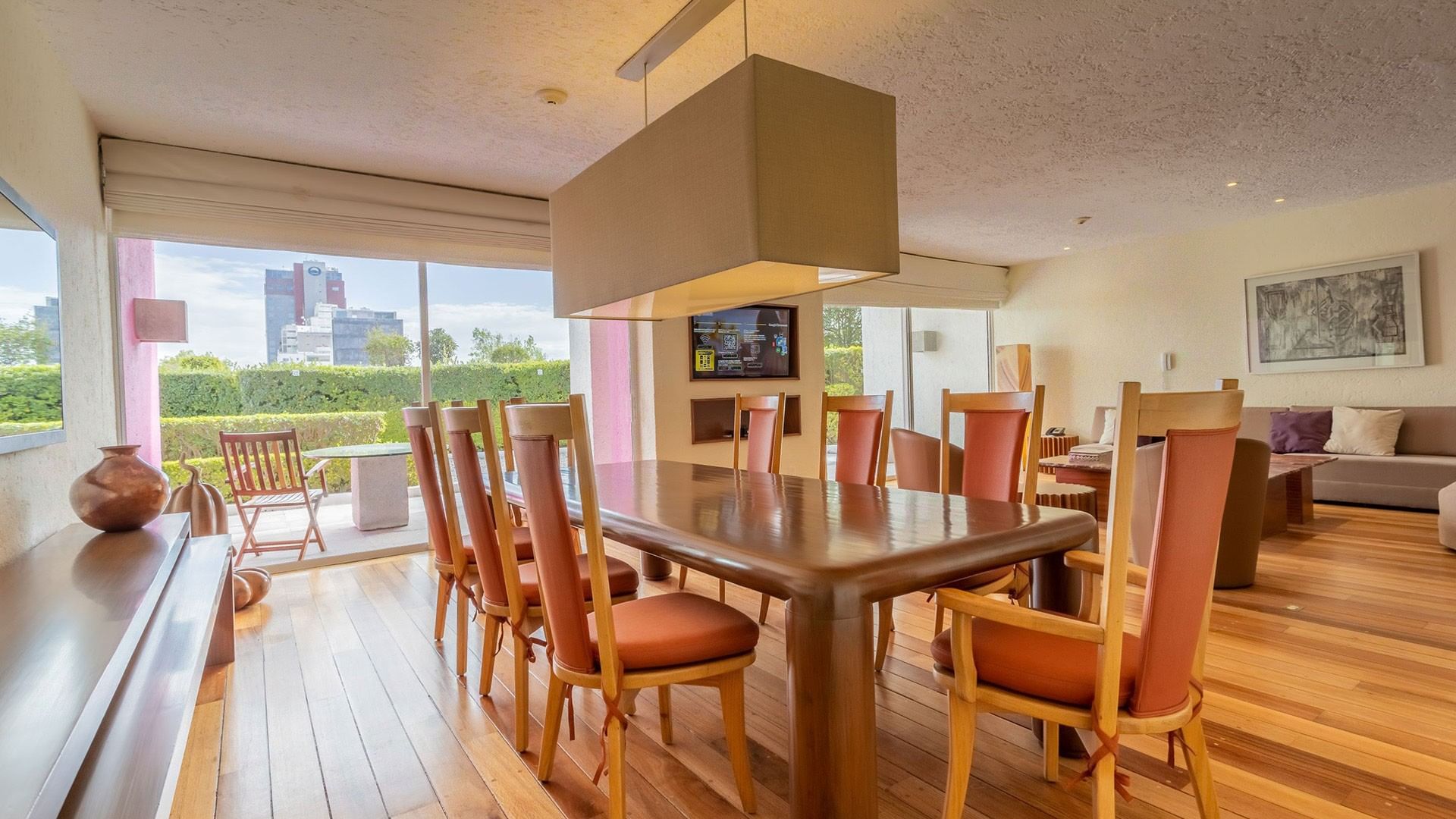 King Viceroys Suite dining table featuring orange chairs and a modern box light fixture at Camino Real Polanco Mexico