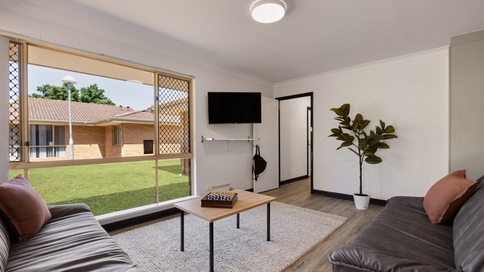 Cozy living room with couch, coffee table, and TV at UniLodge at Curtin University - Vickery House.