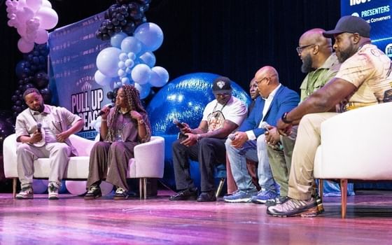 Panel discussion on stage with speakers seated on white chairs amid blue and pink balloon decorations at Showboat Hotel & Resort Atlantic City