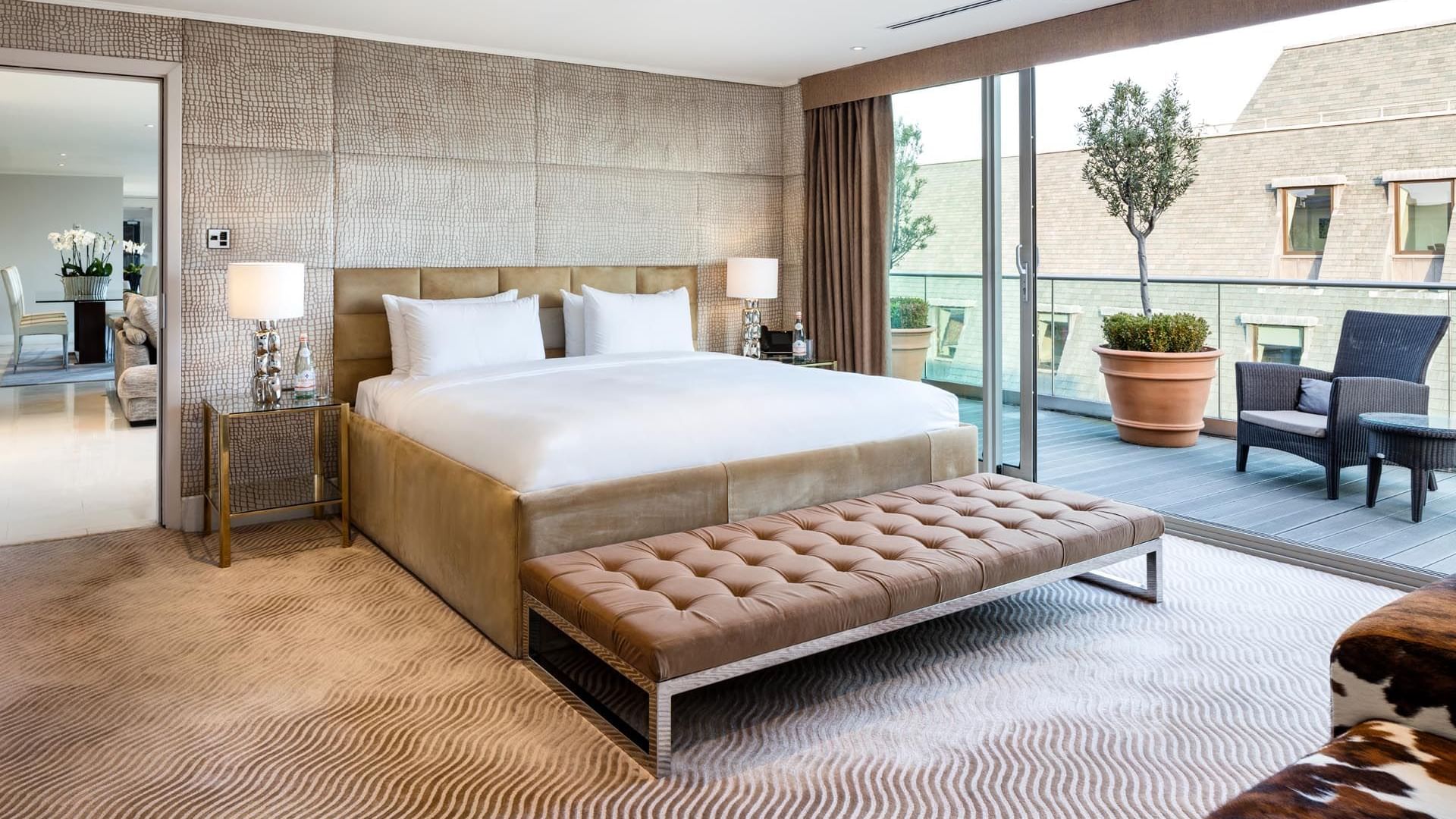 Spacious Penthouse Suite with a king-size bed and natural light streaming in through the balcony at The May Fair Hotel