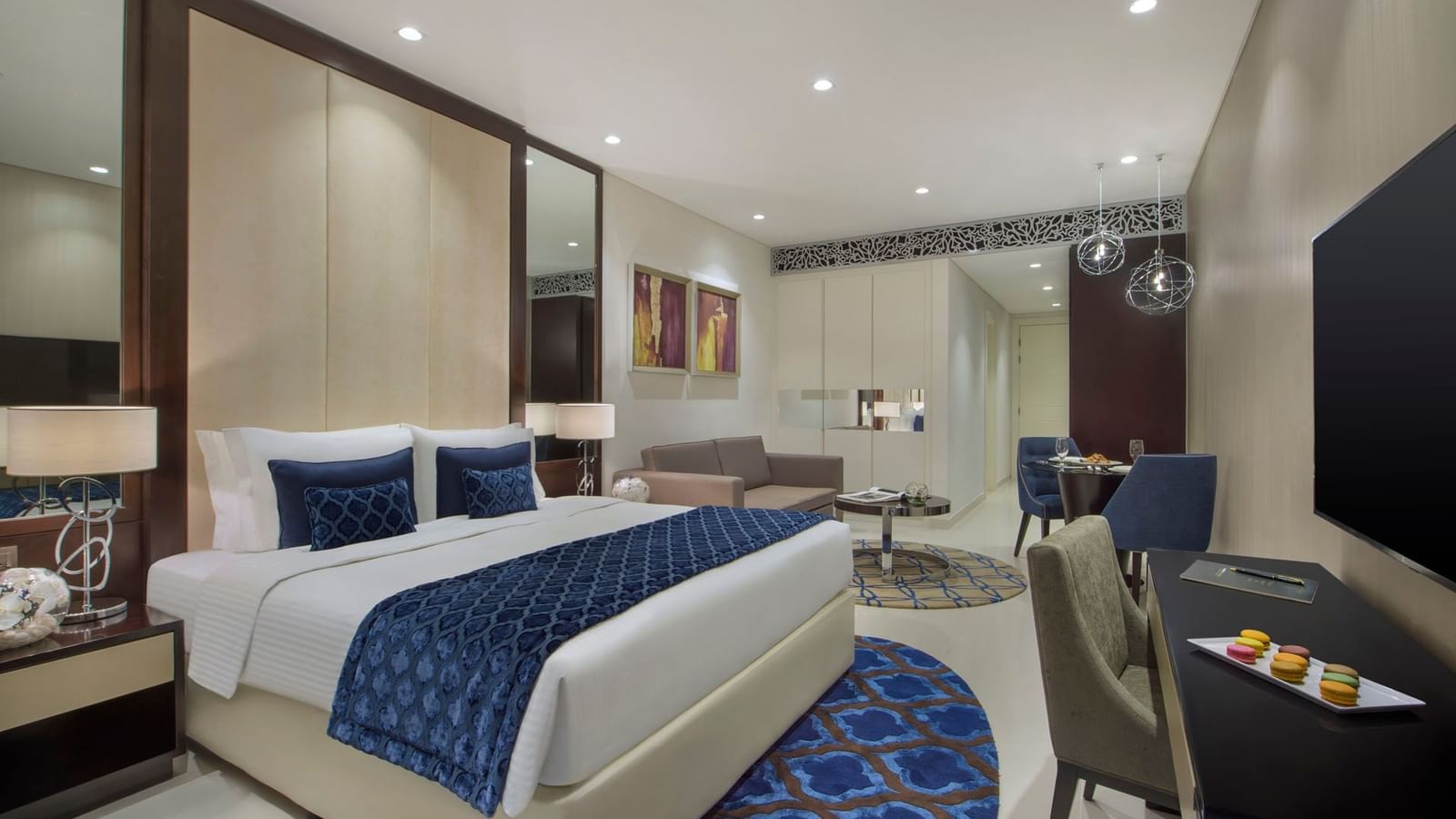 King-size bed, work desk & cozy couch in Deluxe Room at DAMAC Maison Distinction