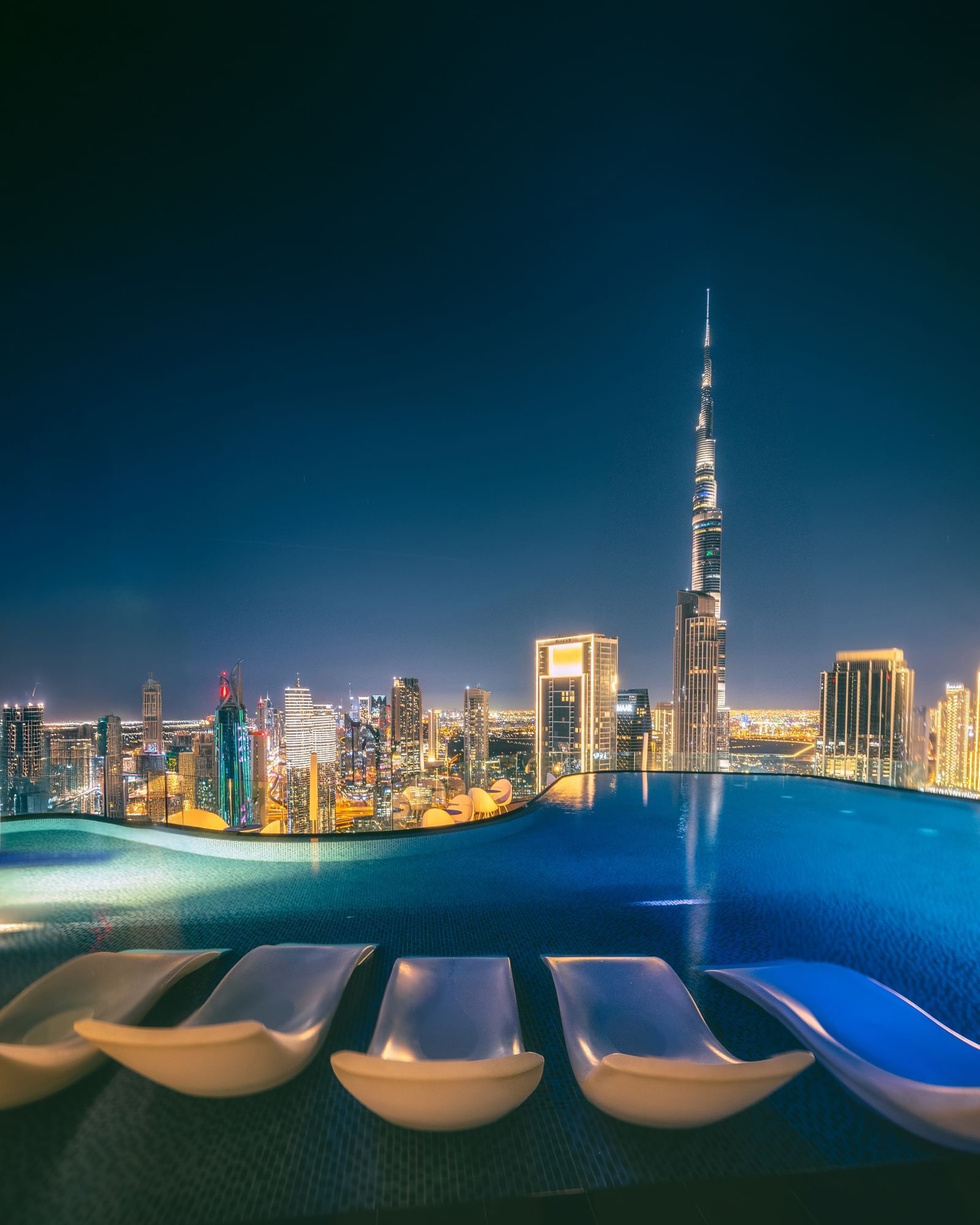 Luxurious rooftop pool at Paramount Hotel Midtown offers loungers and stunning night views of Dubai’s skyline