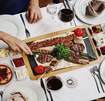 Top view of a person dining with a variety of grilled meats at Titanic Comfort Mitte