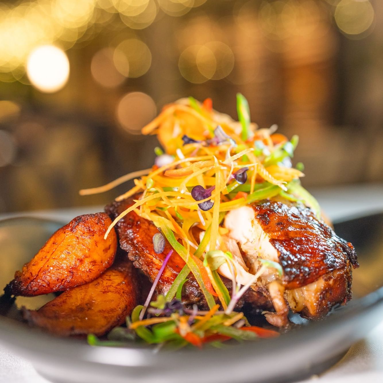 Gourmet grilled chicken and fried plantains garnished with shredded vegetables at Courtleigh Hotel & Suites