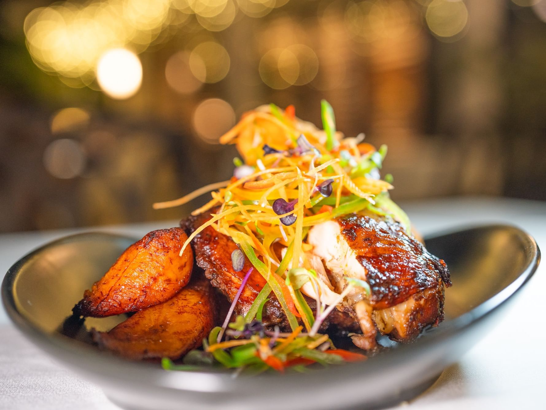 Gourmet grilled chicken and fried plantains garnished with shredded vegetables at Courtleigh Hotel & Suites