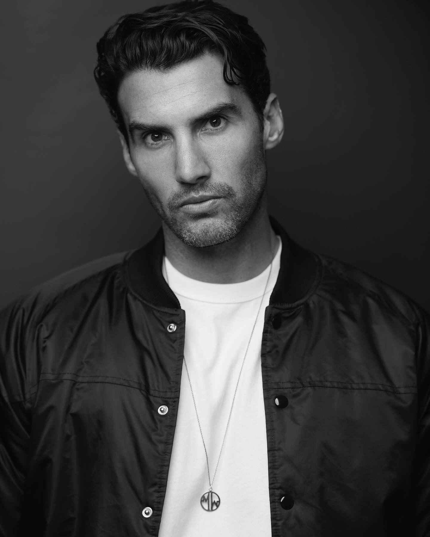 Modern studio at Elysium Hotels featuring a black and white portrait photo of a stylish man wearing a jacket necklace