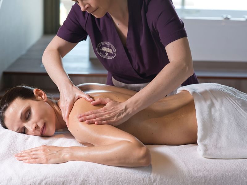 Woman having a body massage in the spa at Le Grand Hôtel des Thermes