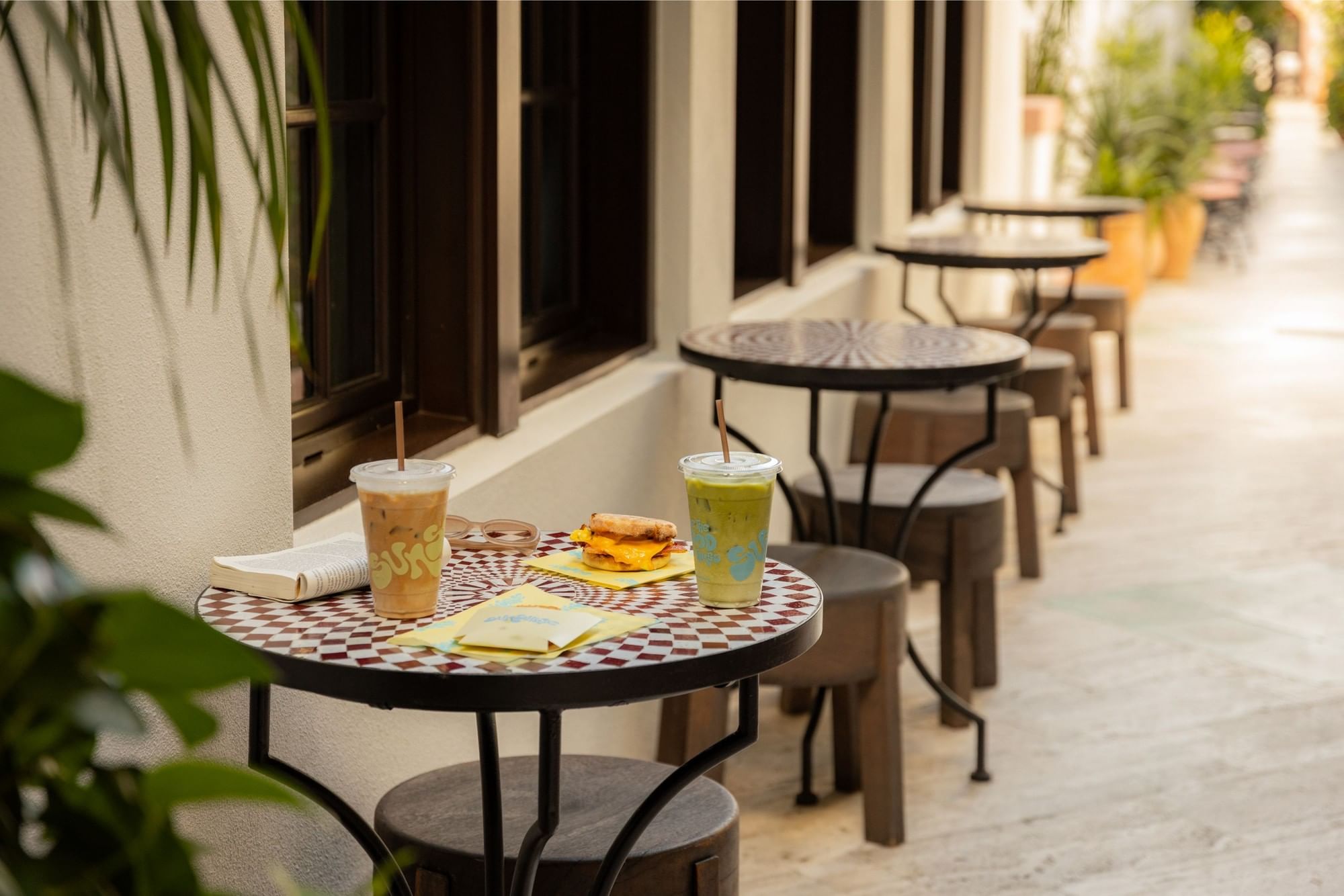 A table with drinks and food in an outdoor seating area.