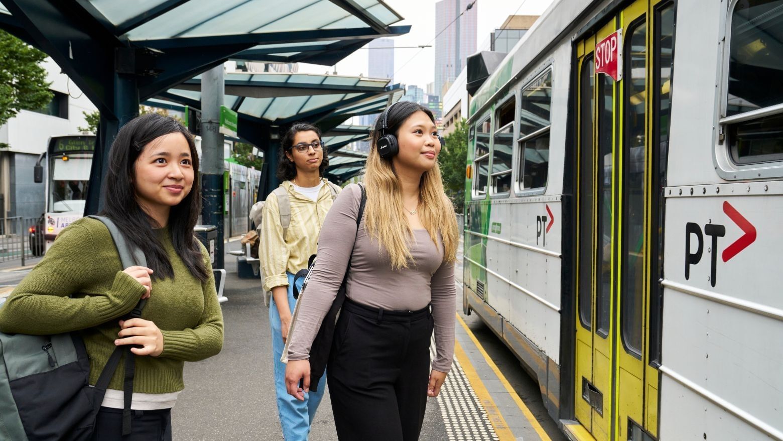 Three students waiting for the tram at Student Living 800 Swanston.