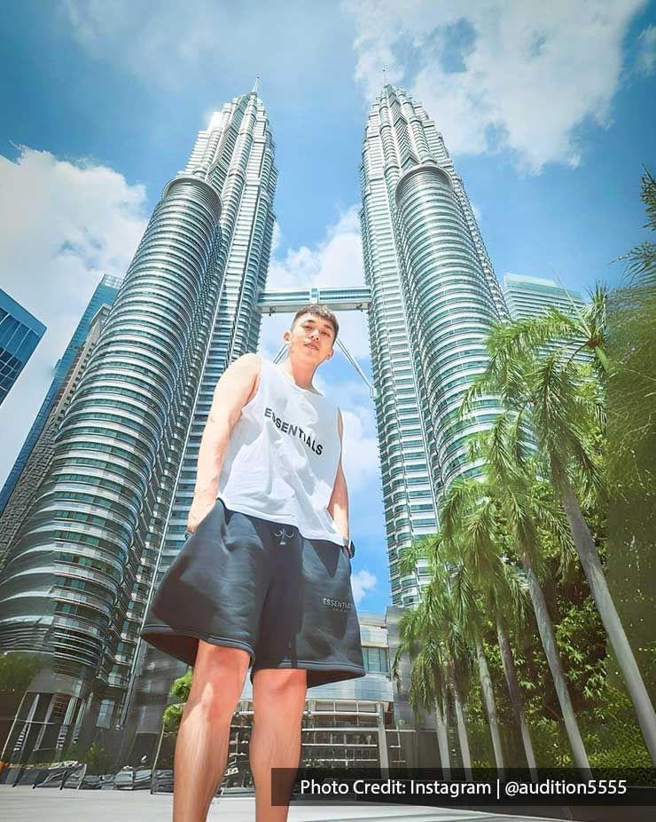 Man posing under The Petronas Twin Towers, famous twin skyscrapers near Imperial Lexis Kuala Lumpur