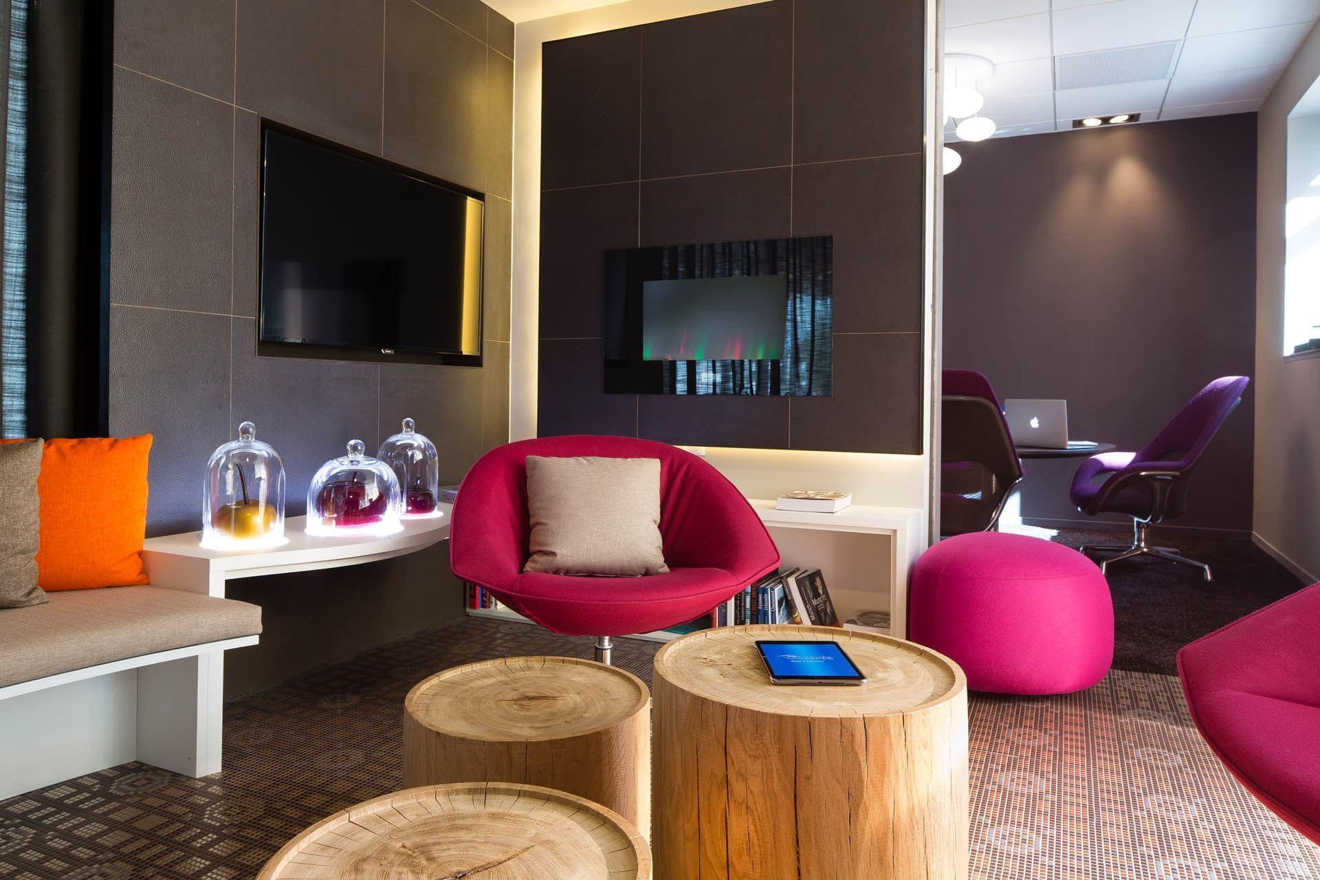 Living area with wooden stools & poufs at Oceania Rennes
