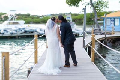 The Bride & groom kissing on a jetty at True Blue Bay Hotel