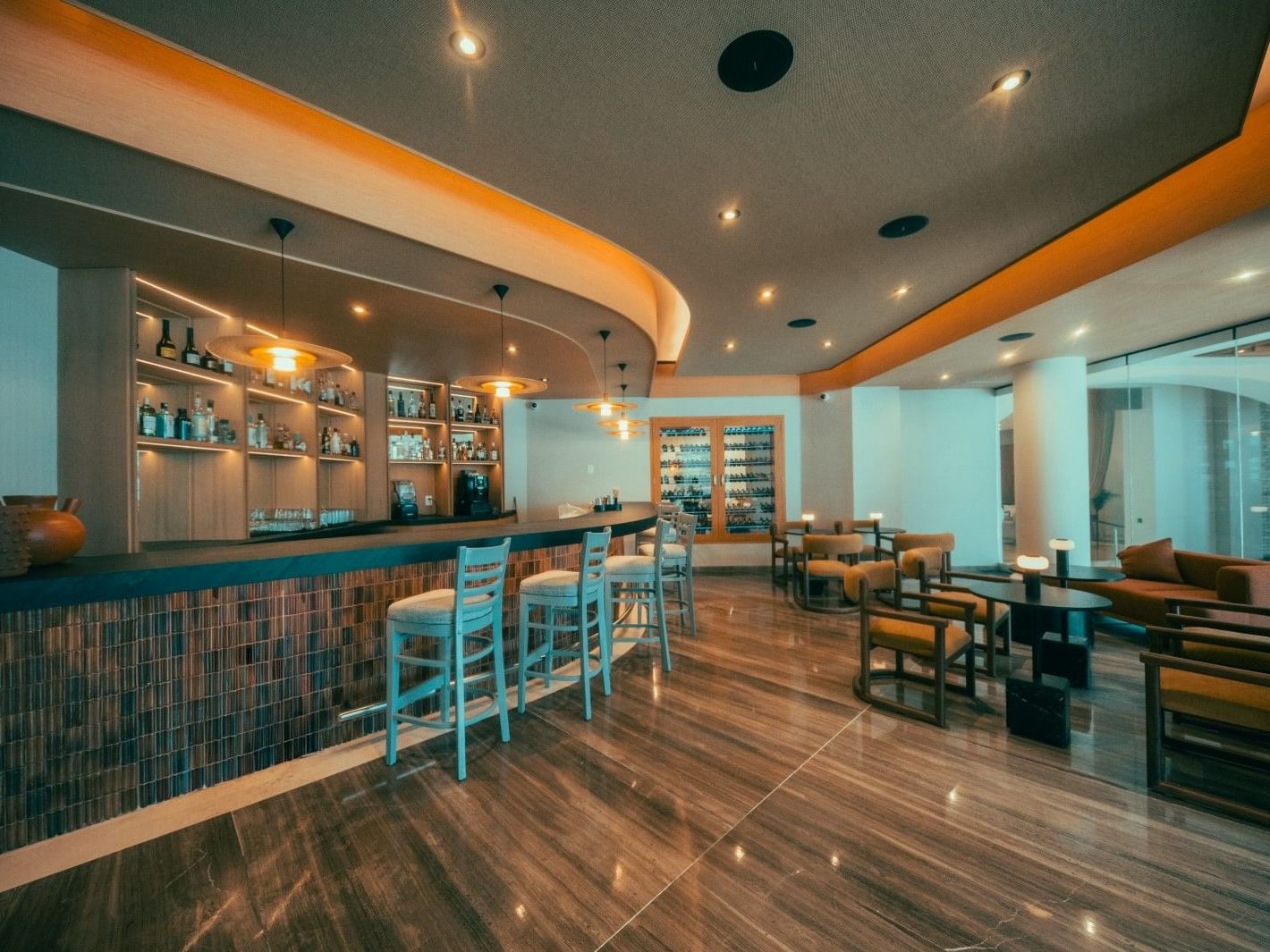 Elena 1927 restaurant interior with modern bar, turquoise accents, and dining area at Villa Premiere Boutique Hotel.