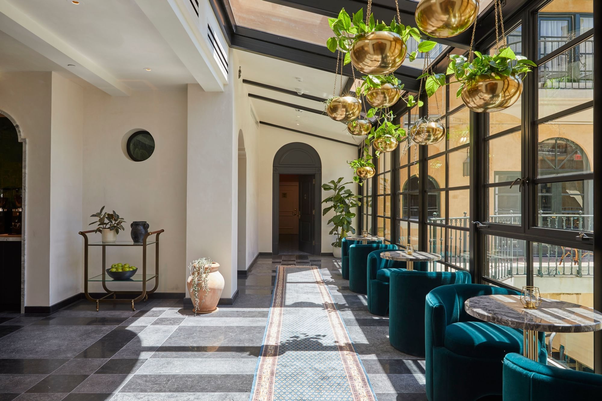 Lounge area with hanging plants and stylish seating at El Prado Hotel
