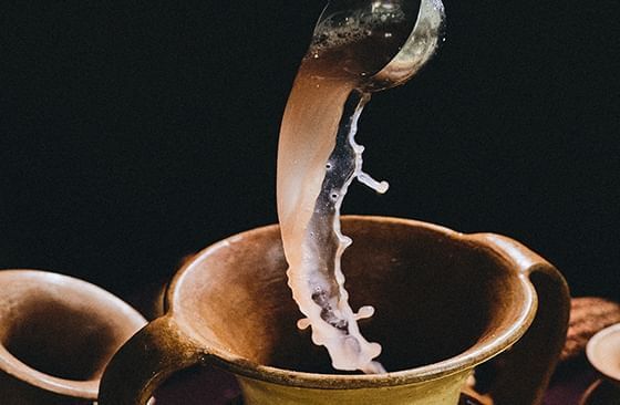 An image of a drink pouring to a two handled cup at Hotel Sumaq