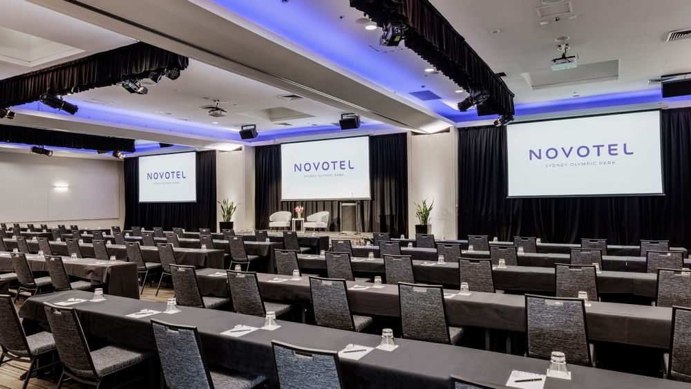 Classroom setup facing the projector screen in Freshwater Ballroom at Novotel Sydney Olympic Park