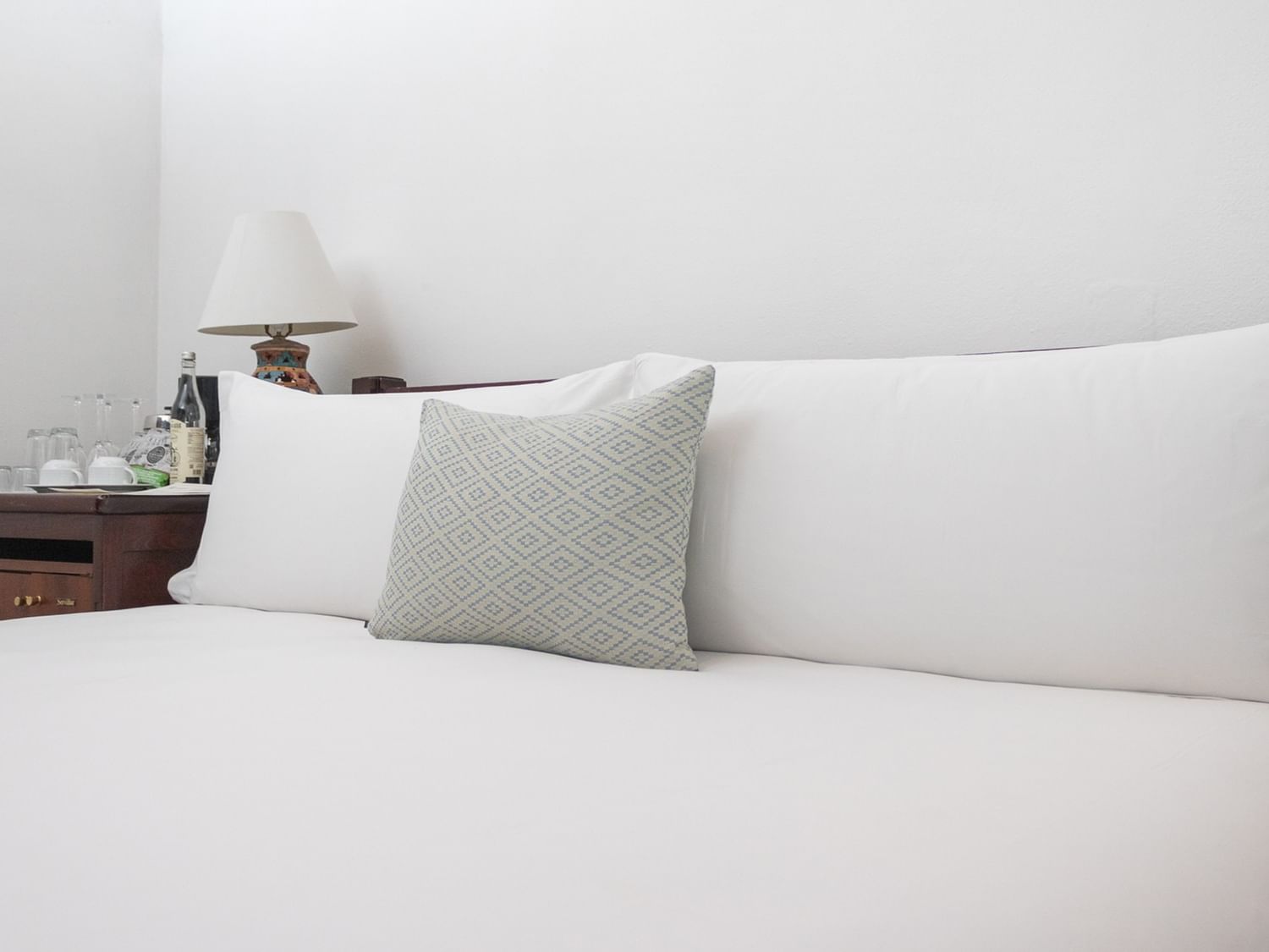 King bed with white linens and pillows in a neatly arranged room at Quinta Real Oaxaca in Oaxaca de Juarez.