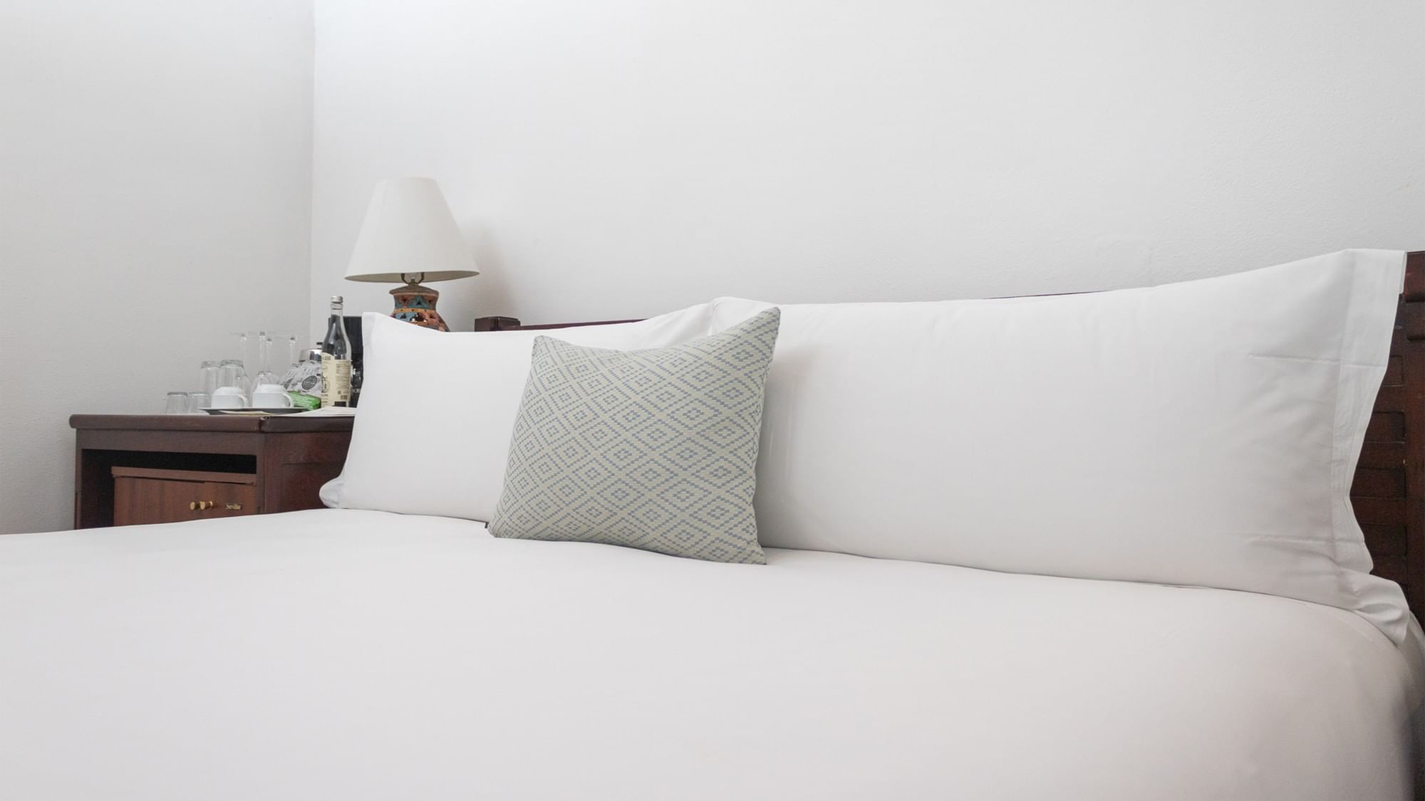 Cama con sábanas y almohadas blancas en la habitación Novicia King de Quinta Real Oaxaca en Oaxaca de Juárez